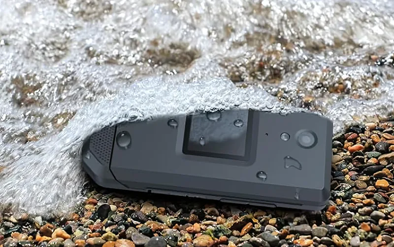 Closed and half-buried in the surf on a pebble beach — what IP68 covers