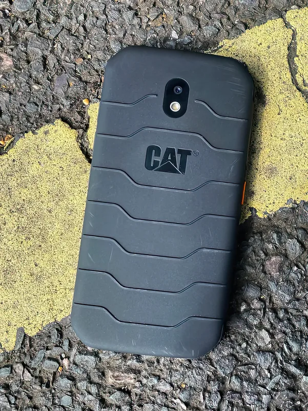 Face down on asphalt — the moulded grip pattern and orange side key