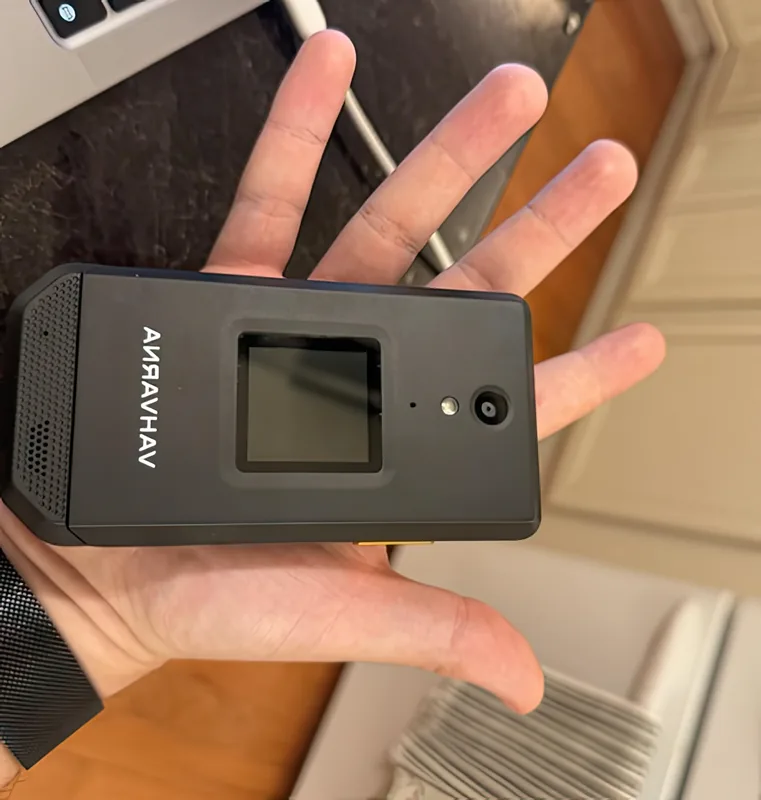 Held in one hand, closed — the phone fills a palm